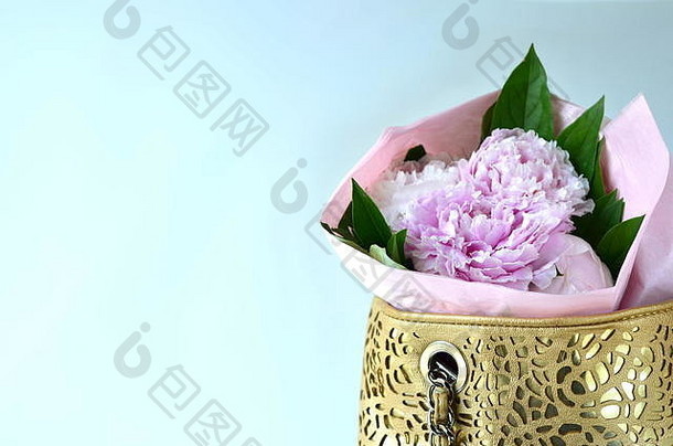 浅粉色牡丹花束用薄纸包在手提包中，并留有复印空间