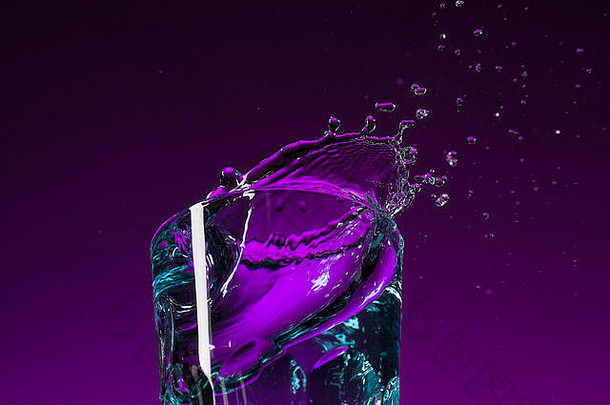 水在紫丁香背景的玻璃中飞溅