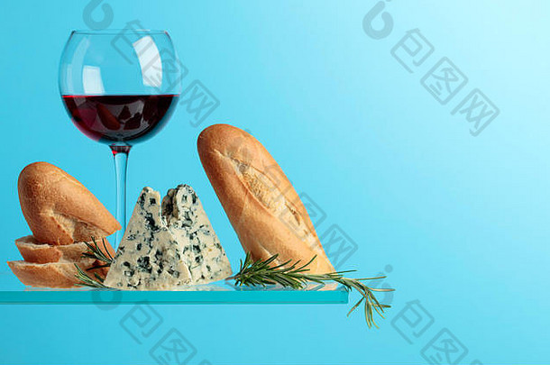 蓝色奶酪配面包、红酒和迷迭香，背景为蓝色。为文本空间。