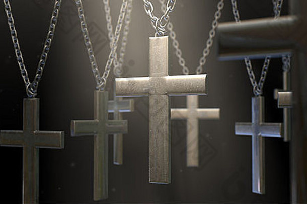 一组金属十字架悬挂在黑暗背景下的链条上