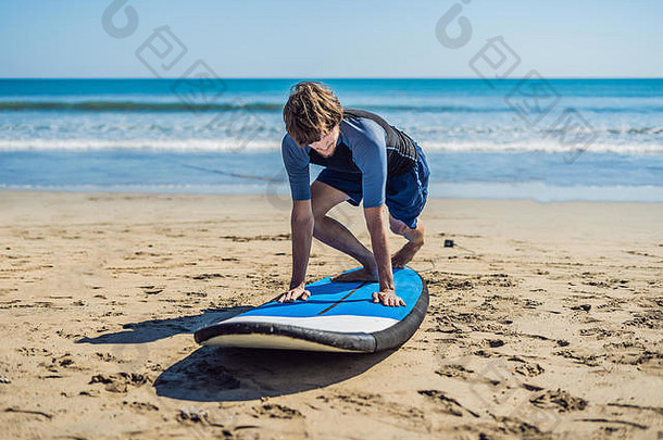 年轻男子在沙滩上排队前接受冲浪训练。学习冲浪。假期的概念。暑假。旅游、体育