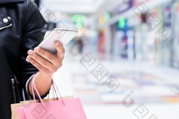 在购物中心使用手机应用程序的一名无法辨认的非洲妇女