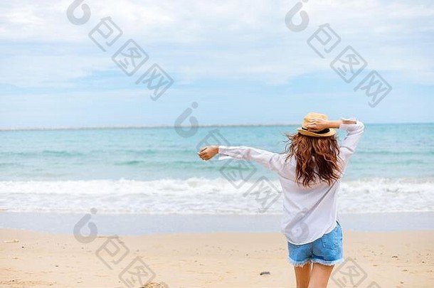 在海滩上散步的快乐的年轻女孩。<strong>暑期旅游</strong>、度假、度假理念。