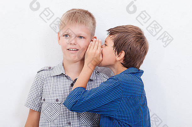 在白色背景下，一个十几岁的男孩在耳边悄悄地告诉朋友一个秘密