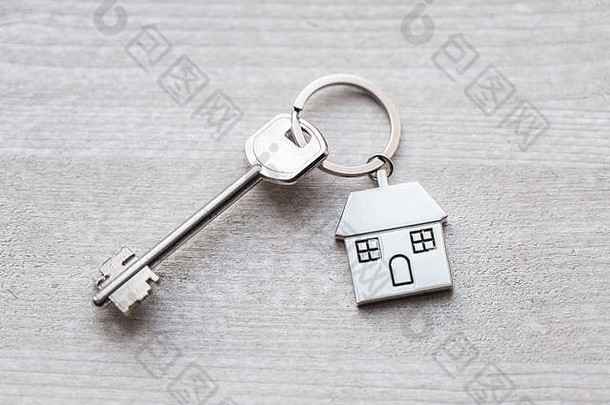 房屋钥匙和钥匙链以房屋的形式放置在木板上。房<strong>地产</strong>、抵押、搬家或物业的概念。