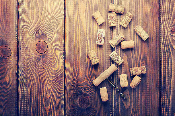 乡村木桌背景上的葡萄酒软木塞和螺旋瓶塞。使用空间从上方查看。复古色调