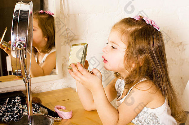 镜子里涂着唇膏的小可爱女孩，试着化妆