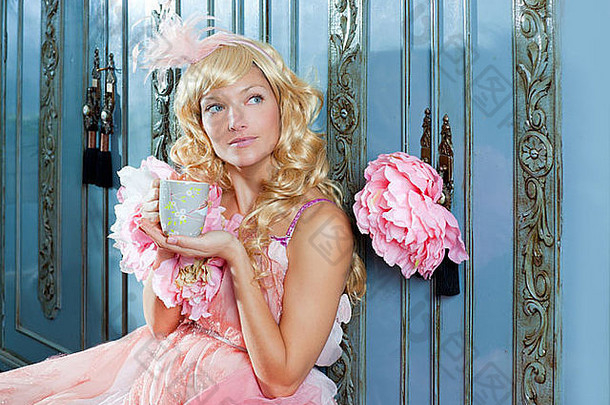 金发时尚公主女士穿着复古粉色连衣裙在家喝茶或咖啡