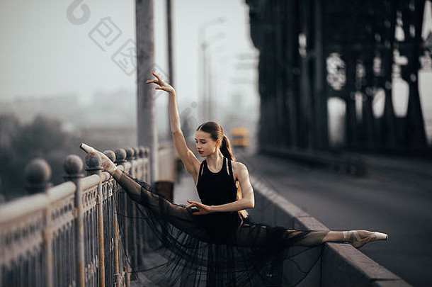 芭蕾舞女演员坐着线构成黑色的透明的衣服桥背景路