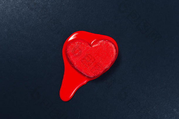 红色心形冰淇淋在深色或黑色纹理的纸背景上融化。爱的概念、情感、情感与心脏病保健