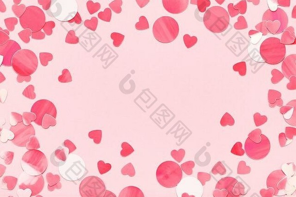 彩色粉色背景上的红心五彩纸屑的节日框架。爱，情人节假期。平放，空间。