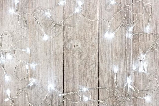 白色圣诞灯框架，浅灰色木质背景上方视图