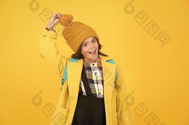 温暖的时尚的快乐小女学生触摸时尚的绒球他孩子微笑时尚的秋天黄色的背景时尚的舒适的