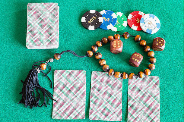 绿色baize桌上的牌组、骰子、代币和烦恼珠的俯视图