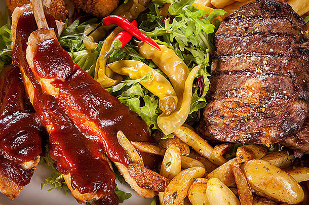 有益健康的盘混合肉包括烤牛排脆皮碎鸡牛肉床上新鲜的多叶的绿色混合沙拉服务法国薯条酸辣酱烧烤酱汁菜