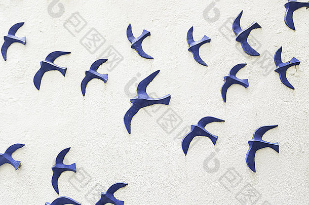 木制墙上的鸟，墙上装饰着蓝色小鸟图案的细节