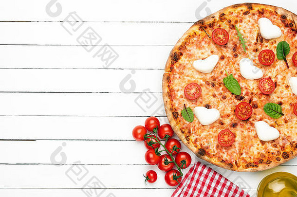 意大利披萨，白木板背景上有马苏里拉、樱桃西红柿和酱汁。具有文本空间的俯视图