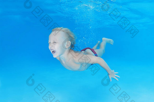 5岁男孩在游泳池里学习水下游泳