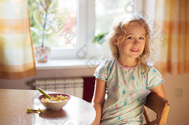 可爱的小女孩正在吃早餐，麦片和牛奶