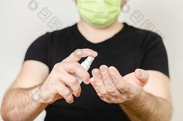 男子用<strong>洗手液</strong>喷雾和手术面罩保护自己<strong>免</strong>受疾病传播和COVID-19.灰尘和烟雾保护