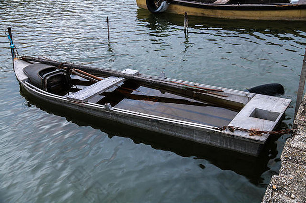 漂浮在水面上的古老的木制小渔船。他们站在小码头上。
