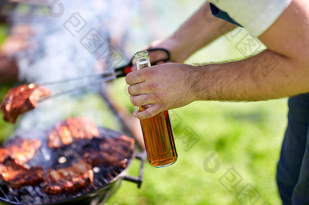 在夏季聚会上，一名男子在烧烤架上烧肉