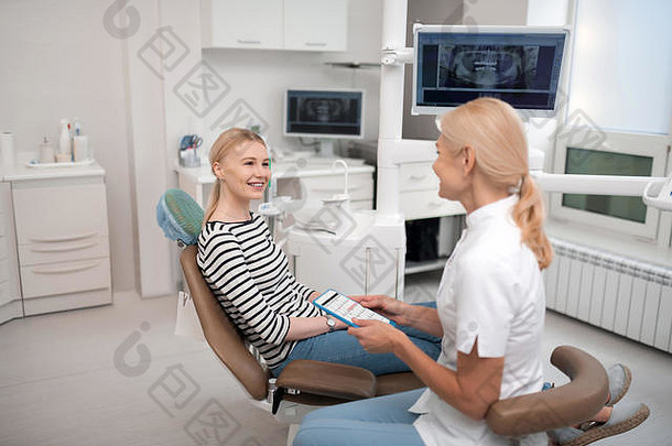 牙医向她的病人咨询未来的预约。