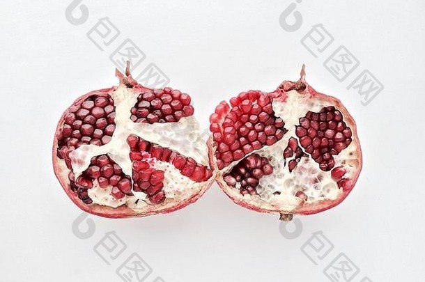 石榴新鲜水果切成两半，在白色背景上分开