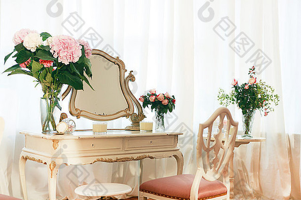 用鲜花和椅子装饰的旧梳妆台
