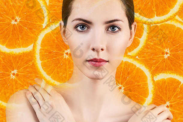 一位年轻的女士在橙色水果片的背景上。