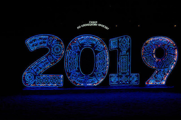 莫斯科梅德韦杰夫科沃区夜间用蓝色led灯数字描绘2019年新年。背景上的俄语led灯文本：Olonets上的方形