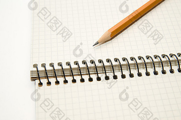 打开的笔记本上有一张白纸和一支铅笔