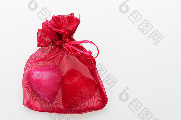 红色和粉色箔纸包裹的心形巧克力，在白色背景上隔离，用于情人节或与爱情相关的问题