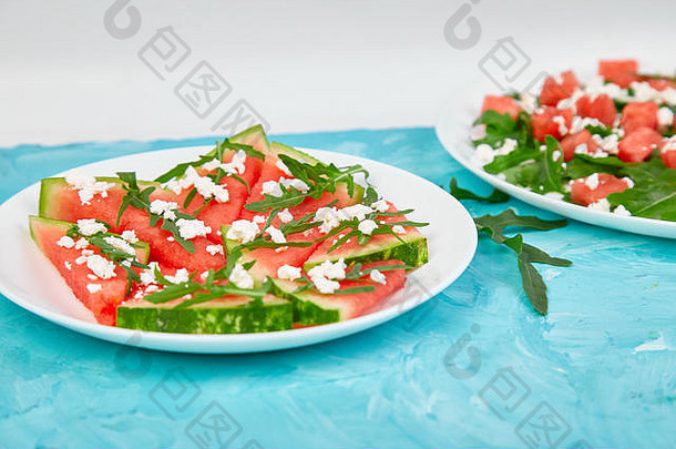 新鲜的夏天西瓜沙拉羊奶酪芝麻菜蓝色的表格背景素食主义者食物饮食素食者复制空间