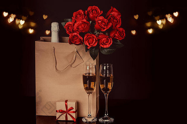 香槟瓶纸袋酒眼镜红色的玫瑰黑色的背景灯背景爱情人节一天概念