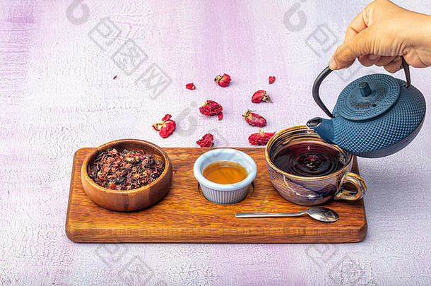 玫瑰果<strong>冲茶</strong>，茶道，一杯新鲜的水果和花草茶，黑暗的心情。热水从壶里倒进一杯茶