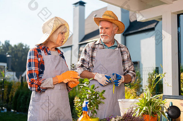 勤劳的夫妇在花园里照料计划和鲜花