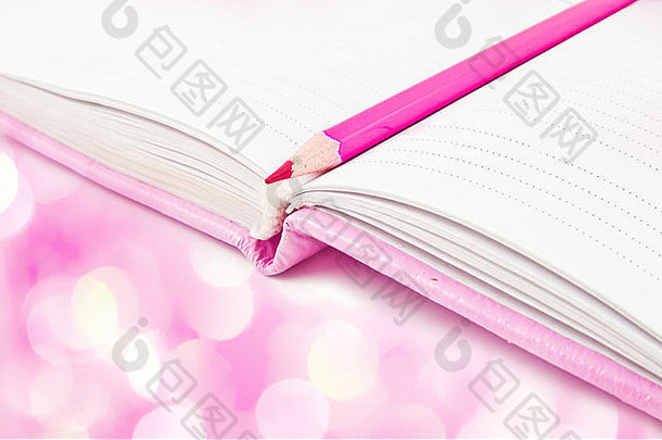 粉红色的笔记本铅笔粉红色的灯背景