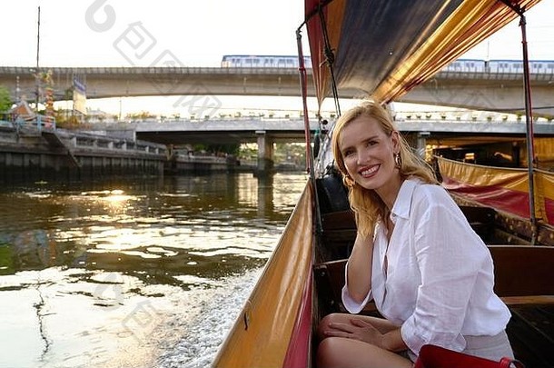 在曼谷，一名女子在一艘长尾船上观光