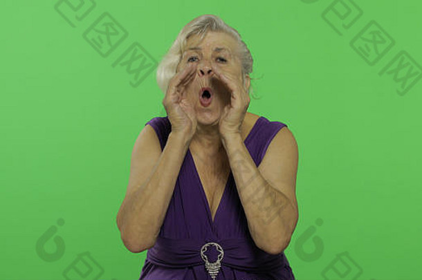 一位老妇人喊道。穿着紫色连衣裙的漂亮老奶奶。放置您的徽标或文字。色度键。绿色屏幕背景