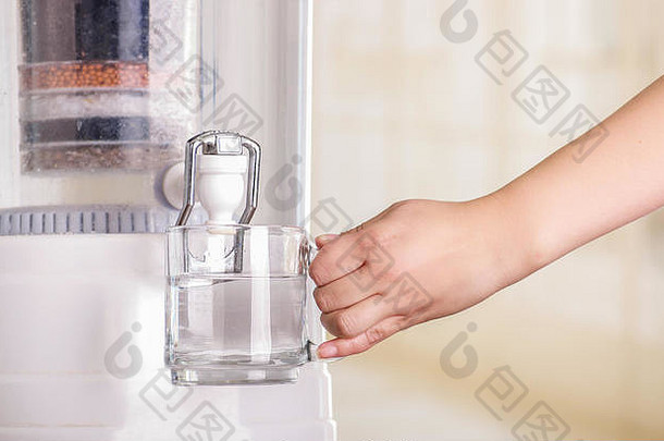 一名妇女在厨房背景上用<strong>净水器</strong>的过滤系统灌满一杯水的特写镜头