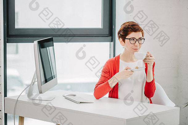 女商人坐着桌子上杯咖啡表格电脑屏幕