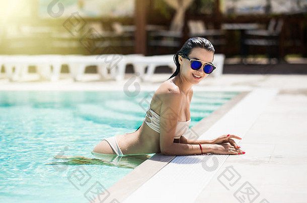 穿着<strong>比基尼</strong>的美丽年轻女子在游泳池里放松