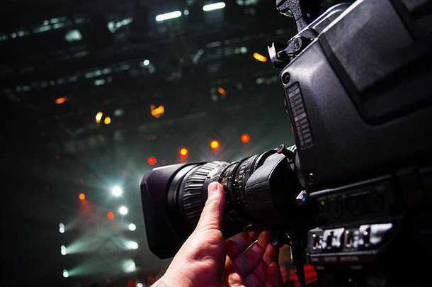 专业摄像机男子电影<strong>演唱会</strong>在舞台上。大型专业4k摄像机为电视台拍摄直播画面。电视摄像机操作员拍摄视频
