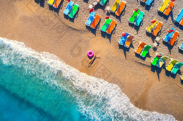 土耳其奥卢德尼兹海面上躺着的戴着游泳环的妇女的鸟瞰图。年轻女孩的夏日景色，蓝色的水，波浪和沙滩，色彩绚丽