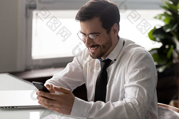 微笑的千禧一代企业家正在阅读带着<strong>喜讯</strong>的短信。