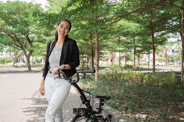 微笑女人亚洲年轻的工人站<strong>折叠自行车</strong>