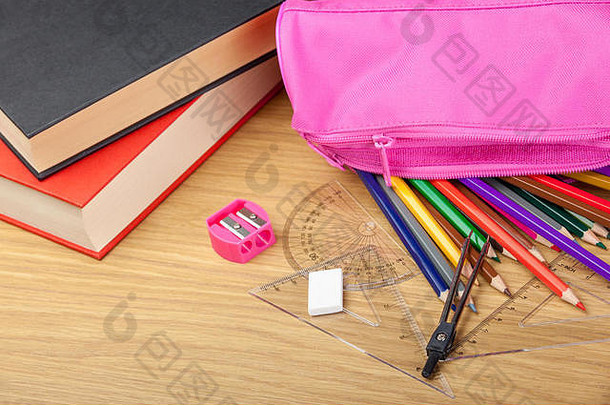 用粉色卷笔刀和书在桌上用粉色铅笔盒涂铅笔