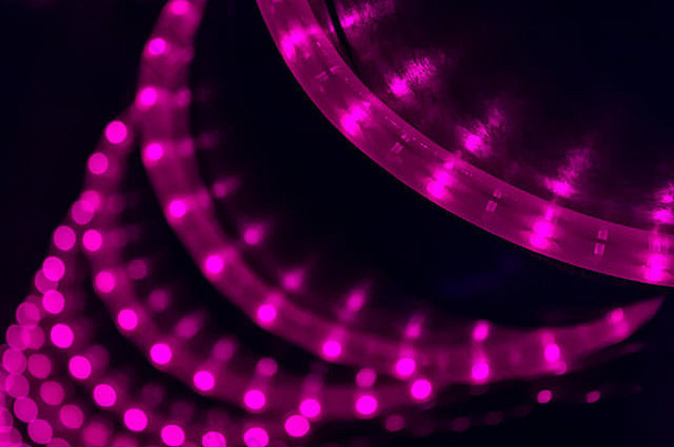 夜总会中，LED紫罗兰色灯串在黑色柱子上盘旋