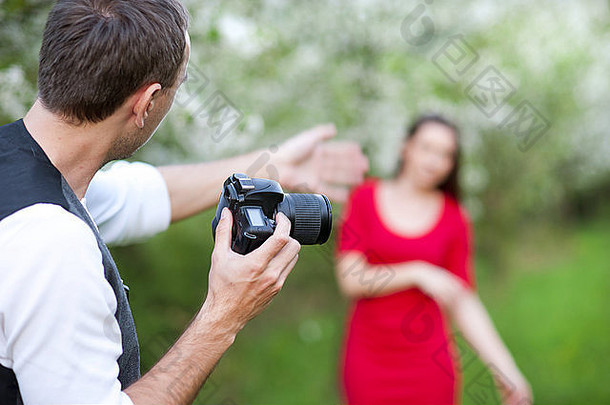 摄影师采取照片美丽的女人红色的衣服自然